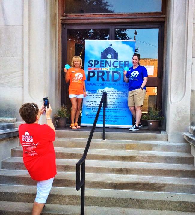 Here, Judi Epp takes a photo of Kim Fidler & Katie Zuber outside the courthouse before the 2015 Spencer Pride Festival.